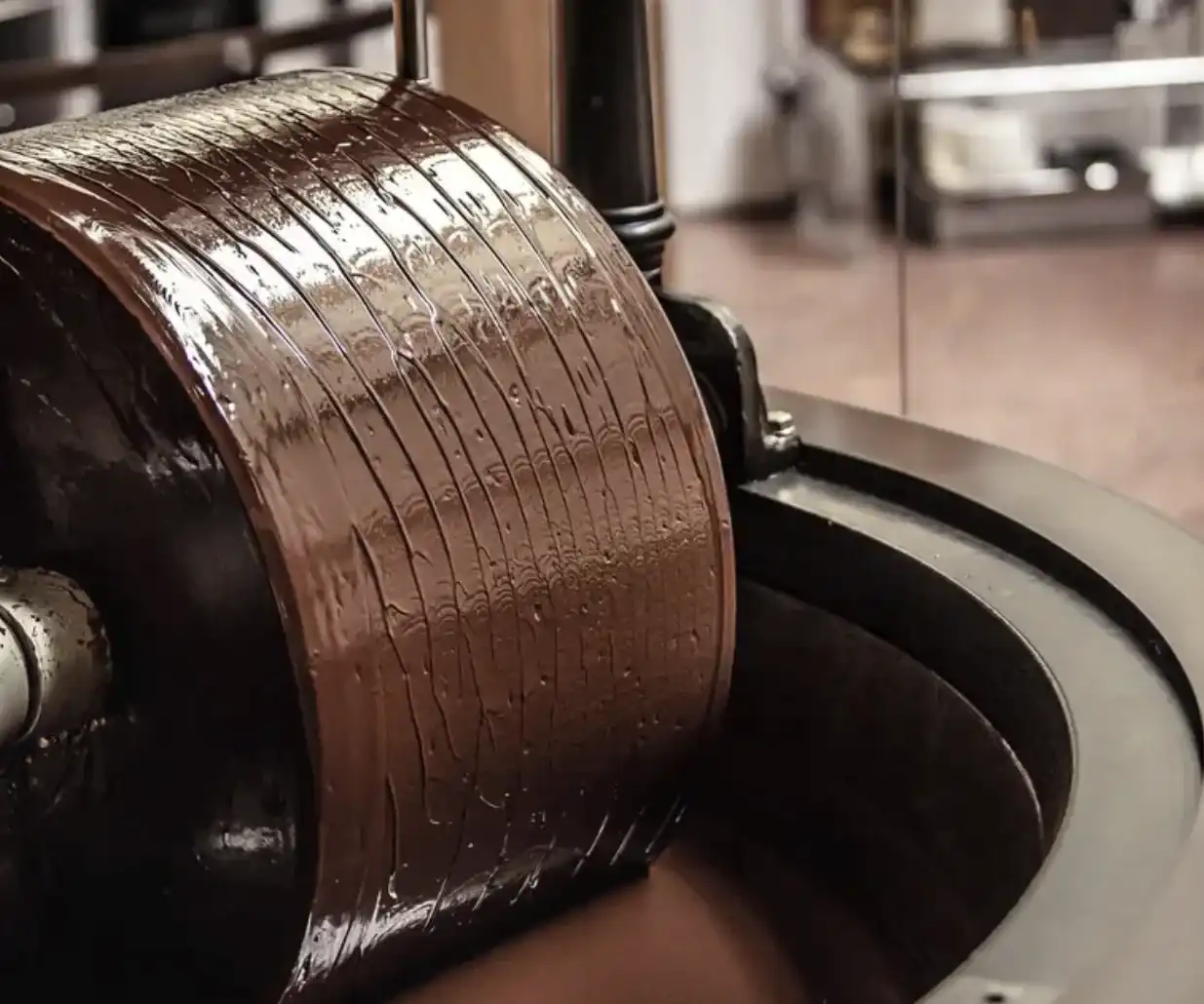 Equipamento industrial realizando o processo de produção do chocolate na fábrica da Dengo.