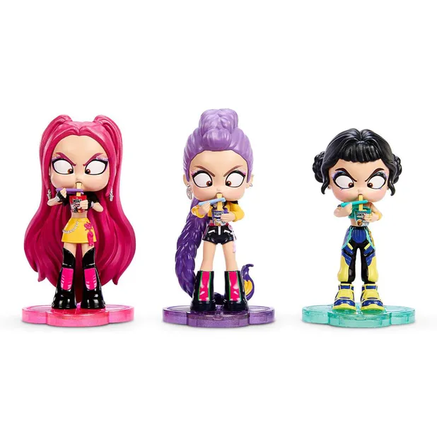Figuras colecionáveis em estilo chibi de Rumi, Mira e Zoey, de Guerreiras do K-Pop, segurando copos de ramyeon sobre bases coloridas