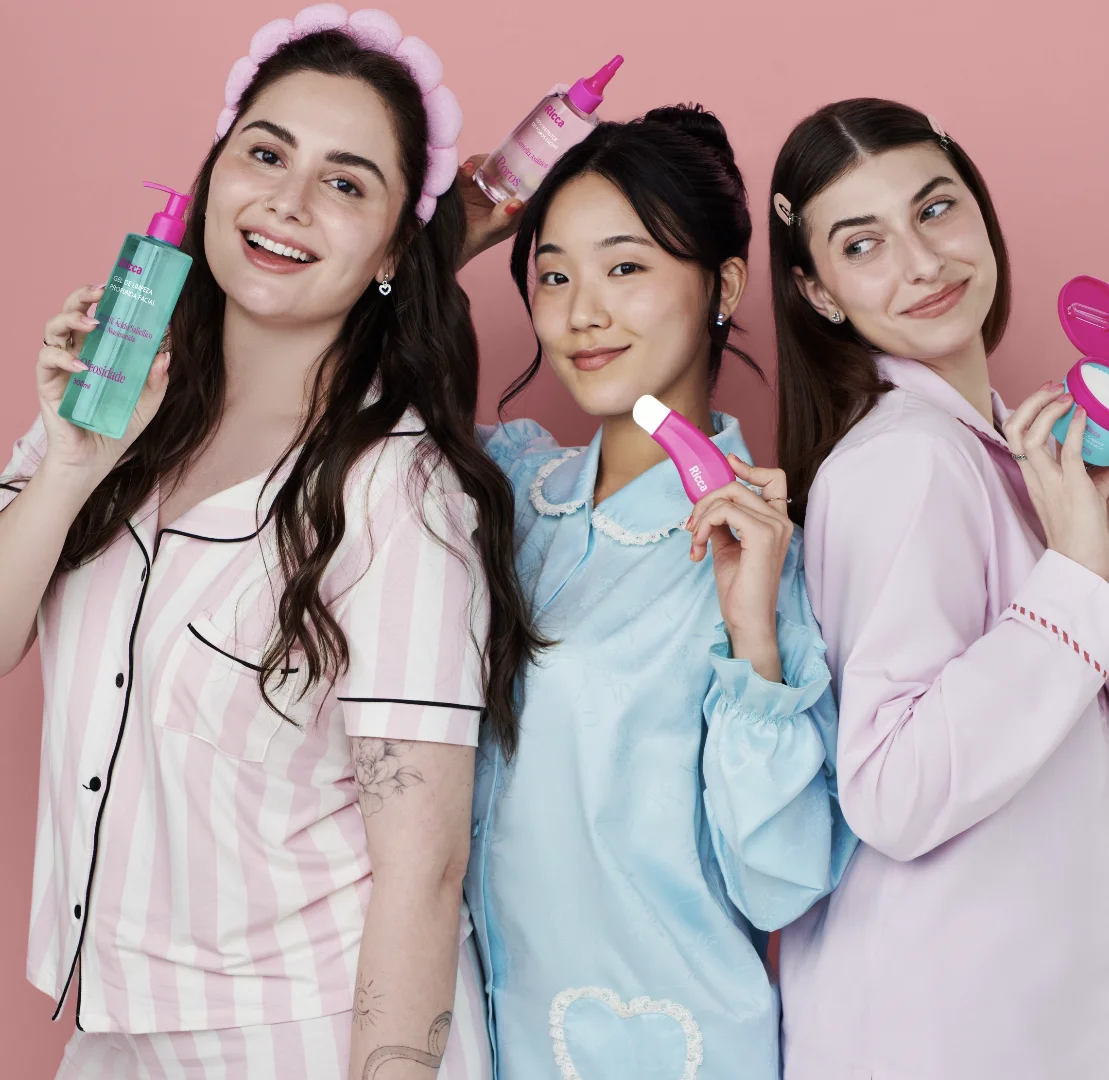 Três mulheres exibem produtos da linha Ricca Acne em campanha de lançamento da marca.