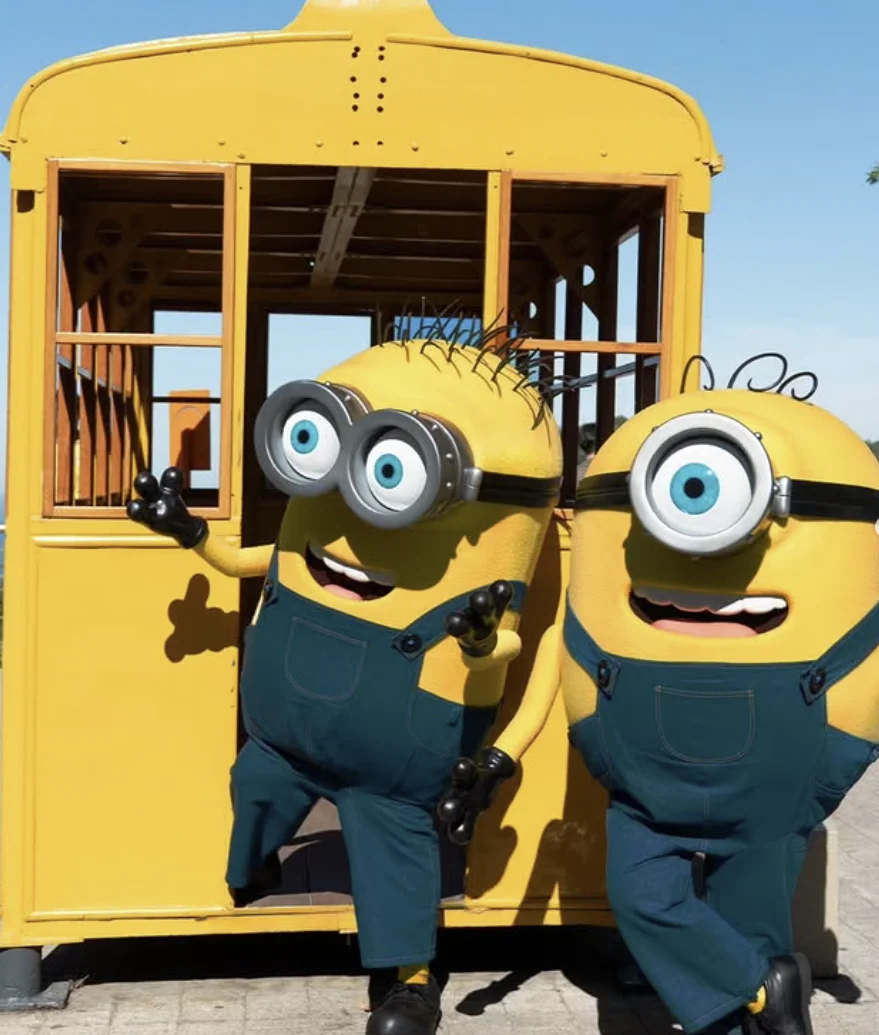 Dois personagens Minions em frente a estrutura temática no Parque Bondinho Pão de Açúcar.