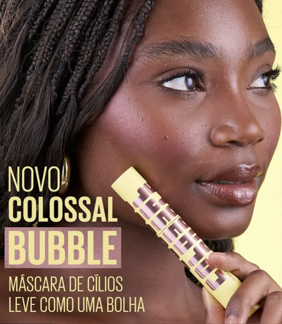 Modelo segura a máscara para cílios Maybelline Colossal Bubble durante campanha de lançamento do produto.
