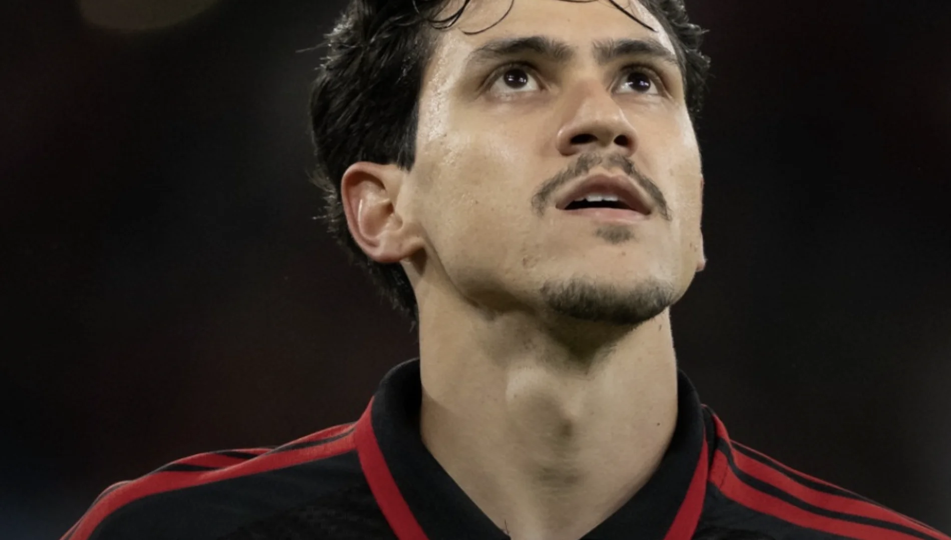 Pedro, atacante do Flamengo, durante partida com uniforme rubro-negro em close no rosto.