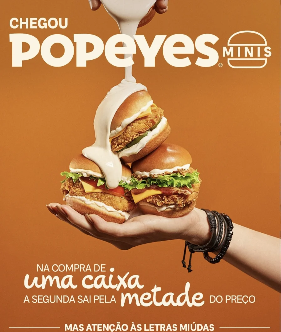 Campanha do Popeyes Minis mostra três mini sanduíches empilhados recebendo molho branco, destacando a promoção da nova linha de lanches.