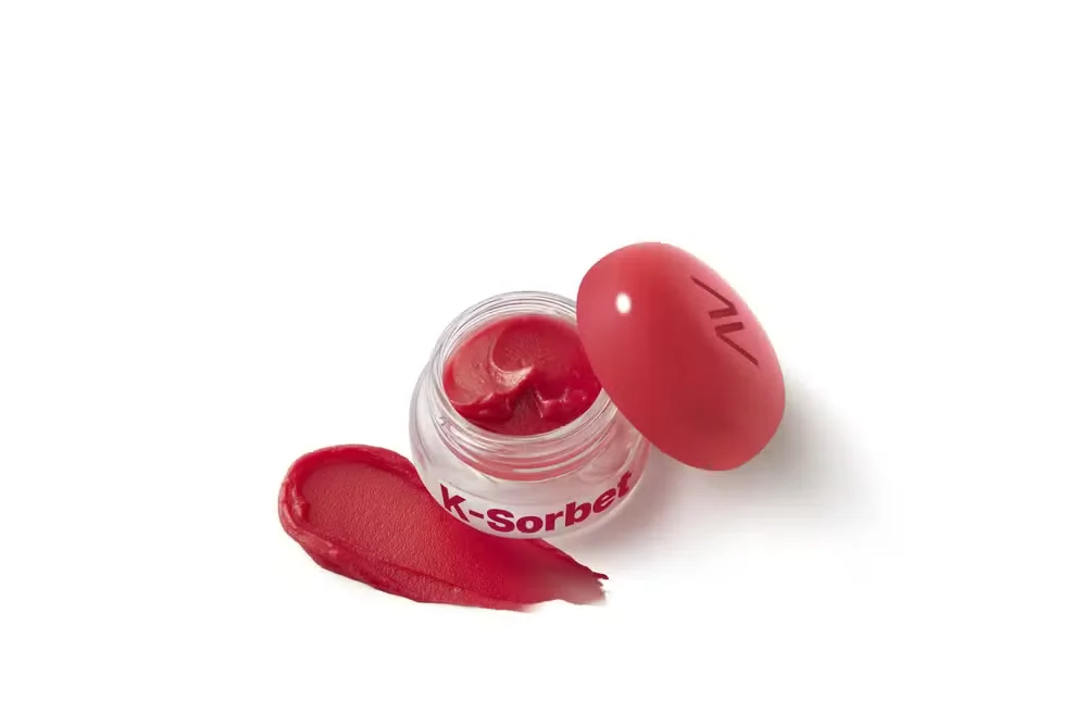 Balm multifuncional Avon Sweets K-Sorbet aberto exibe textura vermelha e acabamento em tint sobre fundo branco.