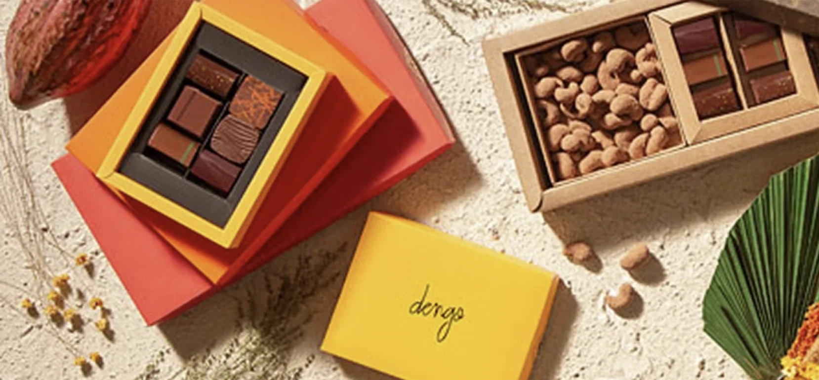 Caixas de chocolates e castanhas da Dengo organizadas sobre uma superfície clara.