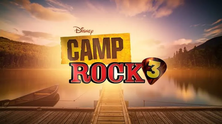 Logo oficial de Camp Rock 3 sobre um píer com lago e montanhas ao fundo durante o pôr do sol.