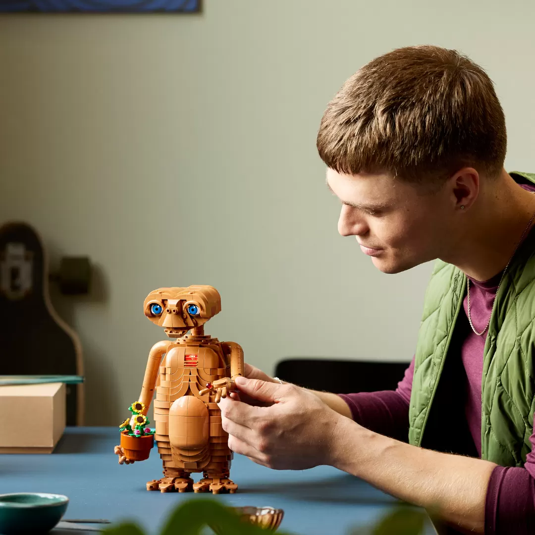 Homem ajusta modelo de E.T. feito com peças LEGO.