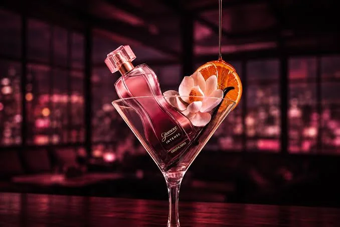 Perfume Glamour Intense do O Boticário em taça com flor e laranja.