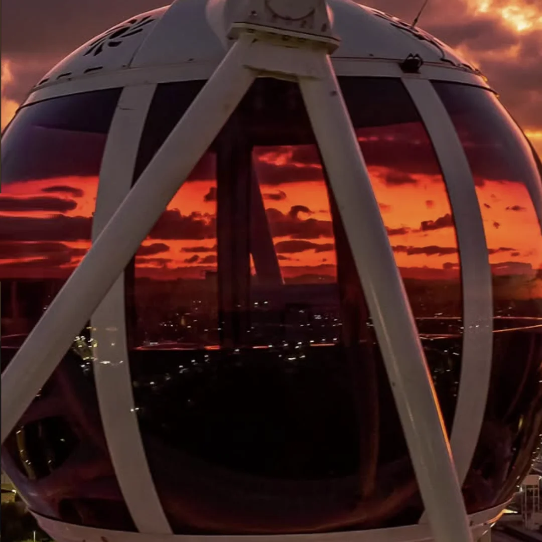Cabine da Roda Rico em primeiro plano, com o céu alaranjado do pôr do sol ao fundo.