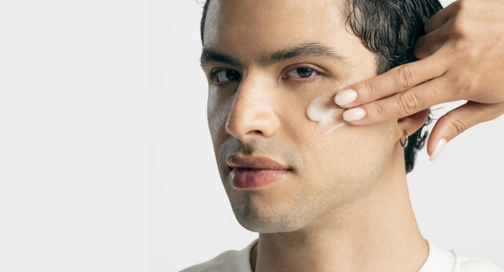 Homem recebe aplicação de skincare no rosto