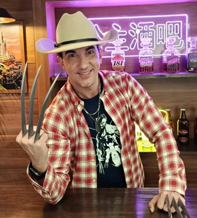 Arthur Machado, dublador de Wolverine, usando camiseta do personagem e garras.