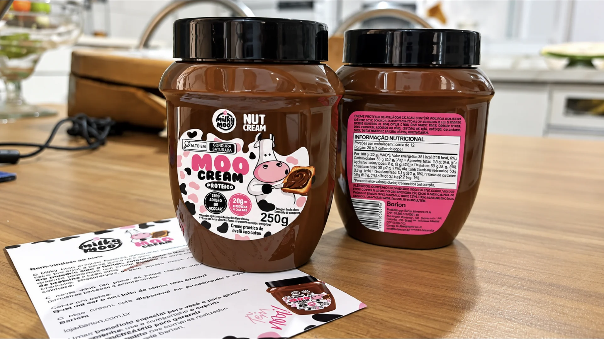 Dois potes de MooCream Proteico da Milky Moo sobre uma mesa, mostrando os rótulos frontal e nutricional.