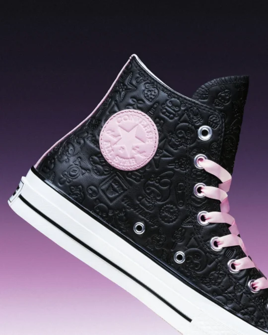 Detalhe do tênis Converse Chuck 70 preto com desenhos em relevo e cadarços rosa.