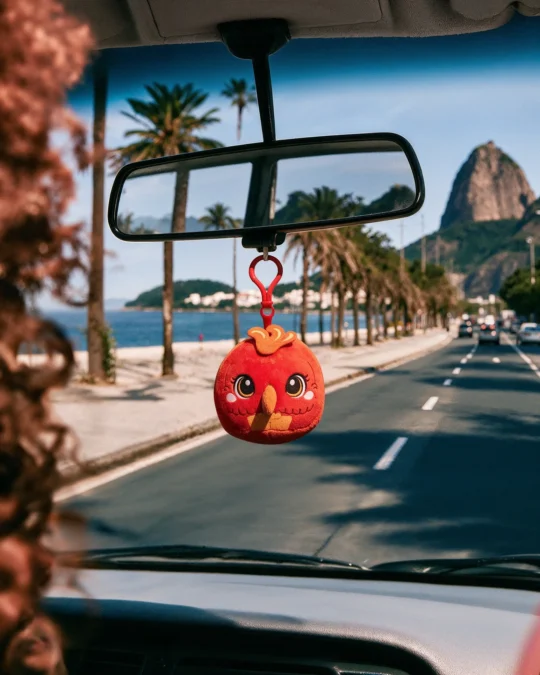 Pelúcia Pássaro Vermelho da coleção Guardiões da Surpresa do China in Box pendurada no retrovisor de um carro.