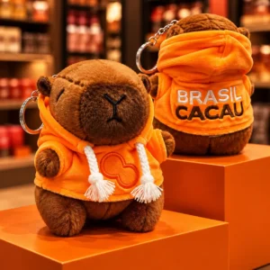 Capivara de pelúcia colecionável da Brasil Cacau vestindo moletom laranja com capuz.