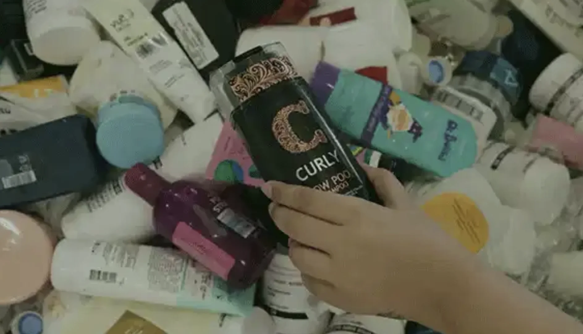 Pessoa separa embalagens vazias de cosméticos para reciclagem pelo programa Boti Recicla.