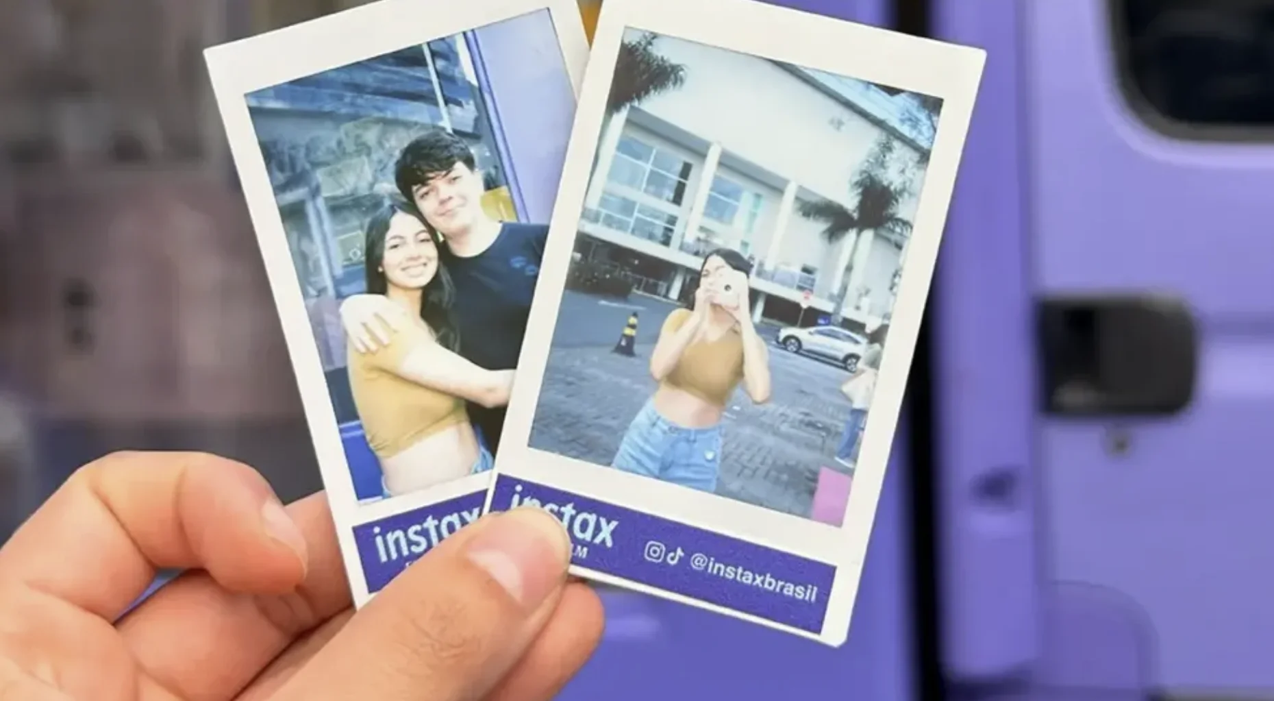Mão segurando duas fotos instantâneas Instax durante ação da marca.