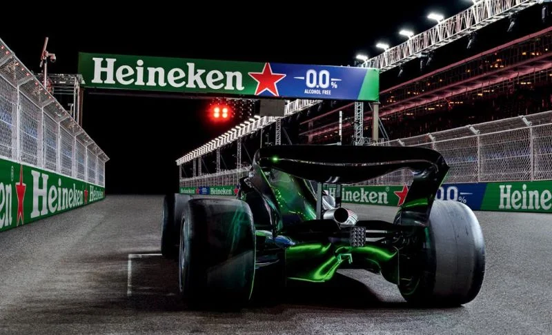 Carro de Fórmula 1 em circuito noturno com publicidade da Heineken 0.0.