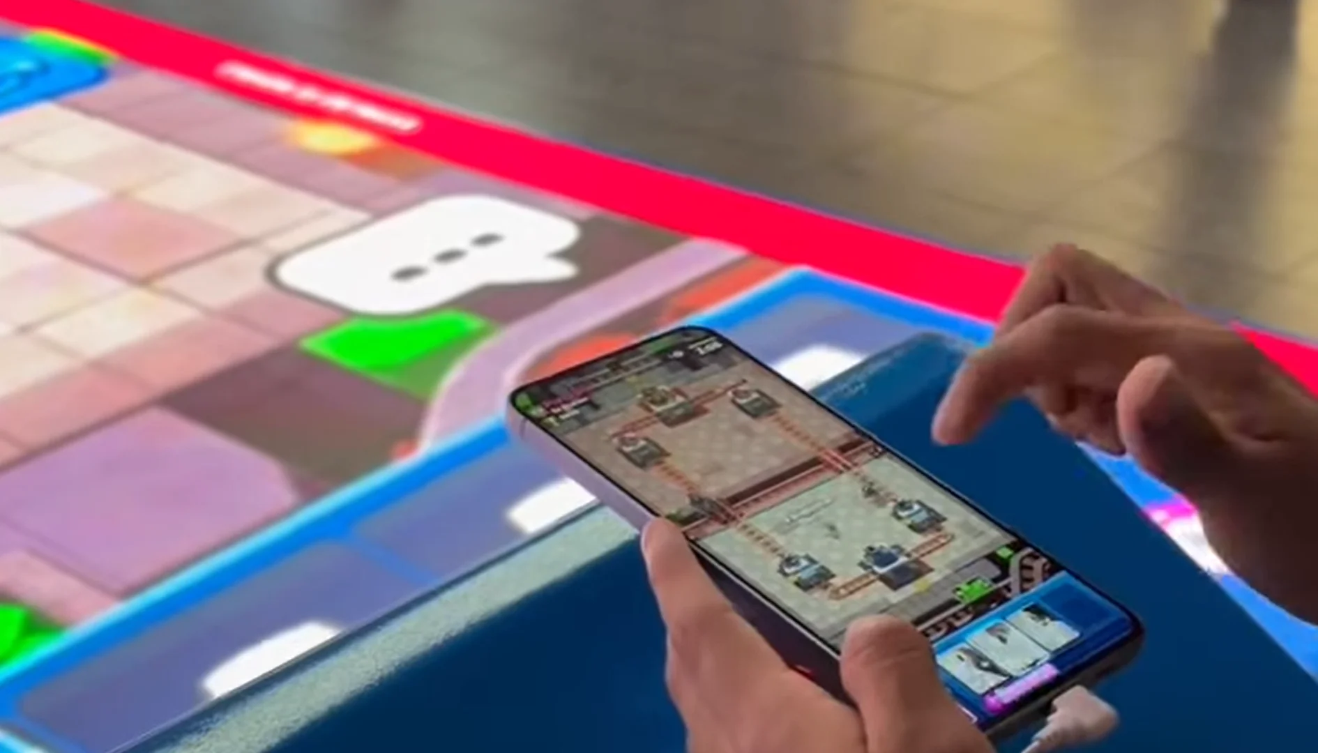 Visitante joga Clash Royale no celular diante da arena temática instalada no Metrô de São Paulo.