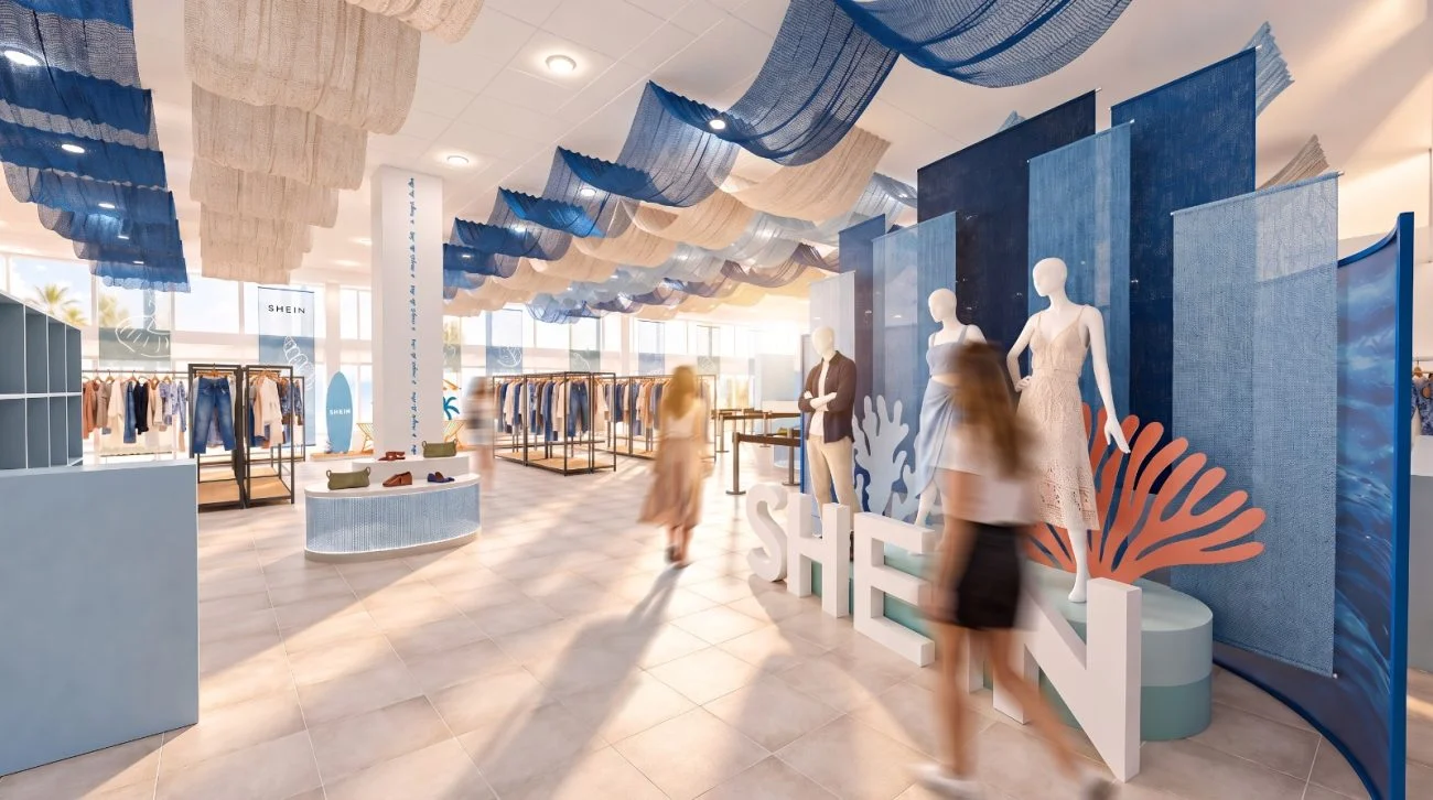 Interior da loja temporária da SHEIN em Florianópolis, com araras de roupas, manequins e decoração inspirada no mar.