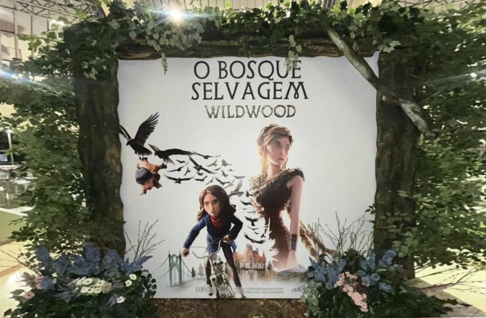 Painel de O Bosque Selvagem com personagens da animação, corvos e decoração de floresta no Shopping Eldorado.