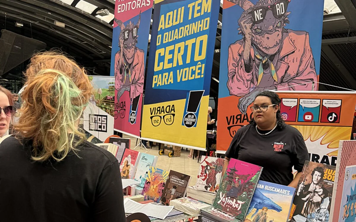 Estande com histórias em quadrinhos e visitantes durante a Virada Nerd.